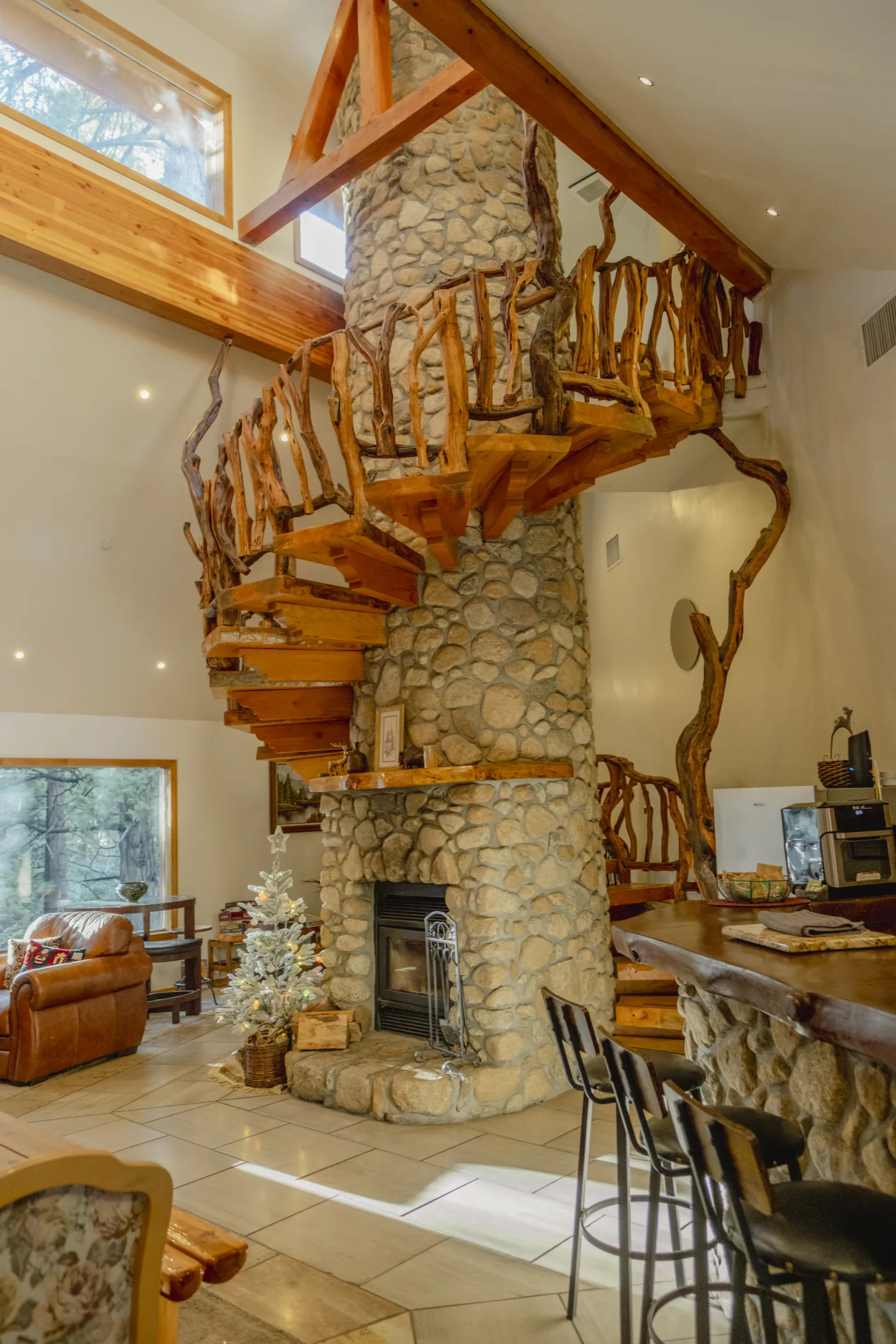 The lodge's hand-built juniper spiral staircase wrapping a river-stone hearth
